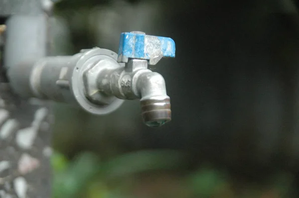 Faucet e fluxo de água desfoque fundo — Fotografia de Stock