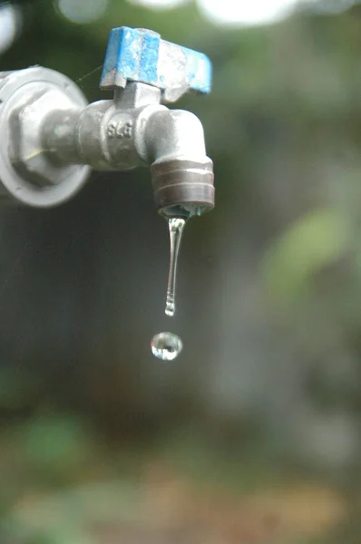 Faucet e fluxo de água desfoque fundo — Fotografia de Stock