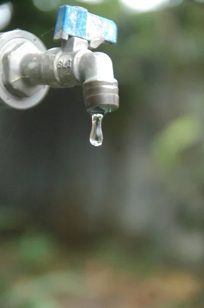 水龙头和水流模糊背景 — 图库照片