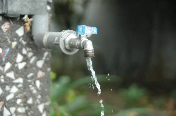 Faucet e fluxo de água desfoque fundo — Fotografia de Stock