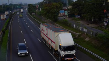 Toll Yolu 'ndaki büyük teslimat kamyonu ve kompakt arabası Bekasi Endonezya yolcu arabalarıyla lojistik araçların ölçeğine ters düşüyor  