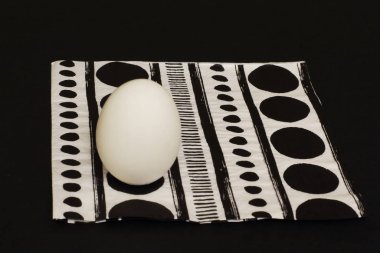 Yumurta ve kağıt peçete ile orijinal zıt geometrik desen siyah arka plan üzerine beyaz. Minimalizm tarzı.