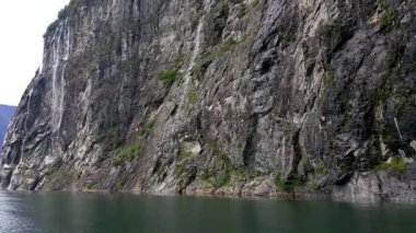 Dağlar ve şelaleler Geirangerfjord. Norveç fiyordu tekne gezisine. Gemide feribot sakin ve bulutlu havalarda çekim. Dağlar ve şelaleler çevreleyen fiyort, görünümünü.