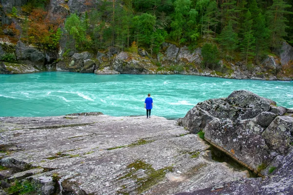 Norveç'te bir dağ Nehri yakınında duran genç kız.
