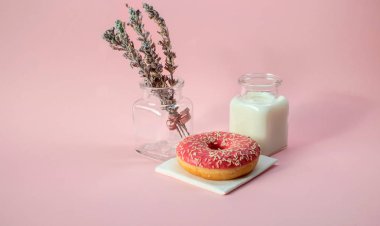 Çörek ve pembe bir arka plan üzerinde süt kapat.