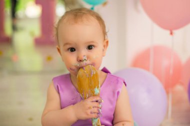 Küçük kız doğum günü pastası yiyor.