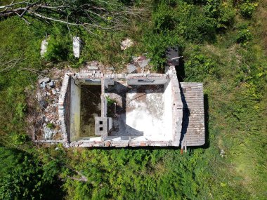 Çayır ortasında çatı ile eski harap ev, orman, çalı, havadan görünüm.