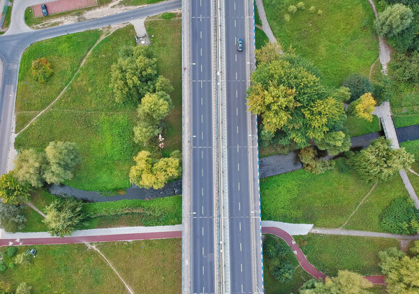 Aerial view on car bridge over road and river in city area