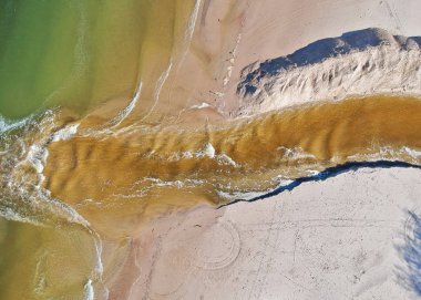 Üzerinde kahverengi nehir denize akan havadan görünümü