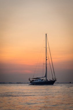 Mutiara Plajı'nda renkli bir günbatımı gökyüzü ile bir tekne