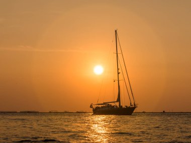 Bir tekne siluet Mutiara sahilde günbatımı gökyüzü karşı