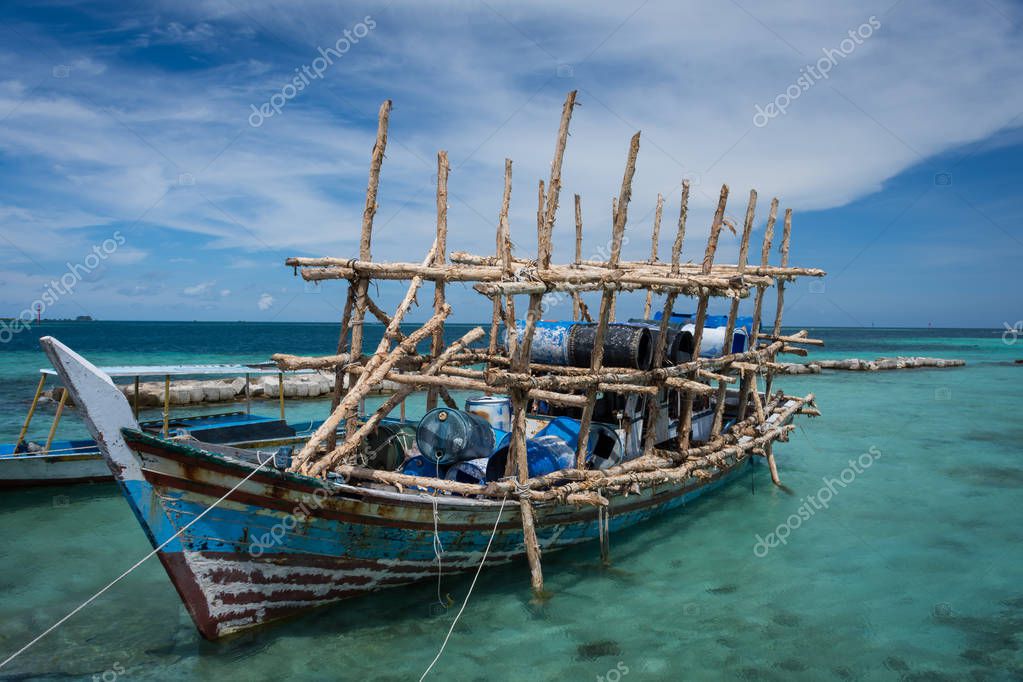 Abandoned Fishing Boat In The Harbor Of Harapan Island With An Unique Wooden Design And Barrel Above It