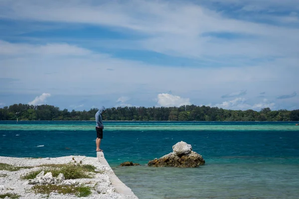 在印度尼西亚哈拉潘岛的海滩边上, 一名男子独自站着。一个人是悲伤的, 只是站着不高兴的时刻 — 图库照片