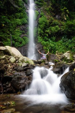 Güzel pürüzsüz su ile Semirang Şelale güzel bir sahne. Muhteşem bir şelalenin tadını çıkaran bir adam. Ungaran şehrinde bir turizm merkezi olan bir Şelale, Semarang, Endonezya.