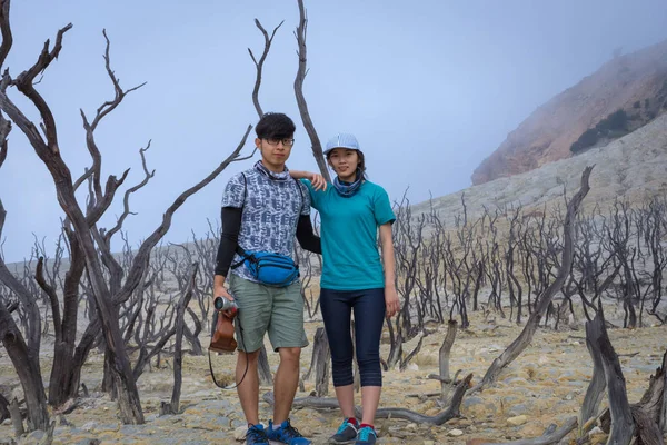 A young korean couple are doing outdoor activities on mountain. Papandayan Mountain is one of the favorite place to hike on Garut