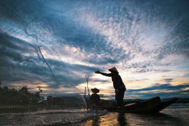 Gündoğumu dönemde Bangpra gölde balık yakalamaya ağları kullanarak balıkçılar.