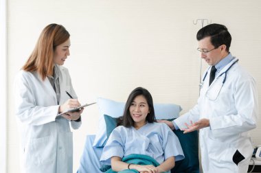 Takım bir doktor Bayan hasta hastane yatağında üzerinde incelenmesi