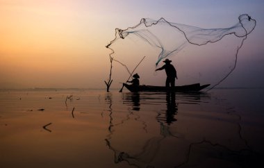 Göle, Tayland balık yakalamak için tekne thorwing balık net Fisher adam.