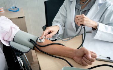 Steteskop ve tansiyon aleti için hastaneden bir hastada kan basıncı kontrol kullanarak doktor.