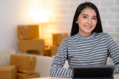 Tabletle çalışan ve gülümseyen Asyalı kadına yaklaş..