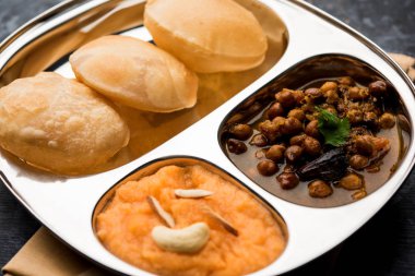 Suji/Sooji Halwa Puri or Shira Poori breakfast, served in a plate and bowl. selective focus clipart