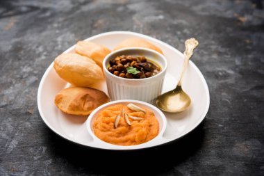 Suji/Sooji Halwa Puri or Shira Poori breakfast, served in a plate and bowl. selective focus clipart
