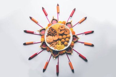 Rangoli veya Diya/kandil Diwali festivali için Hint aperatifler/tatlı ve havai fişek veya patakhe kullanılarak yapılan tasarım 