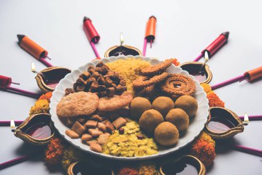 Rangoli veya Diya/kandil Diwali festivali için Hint aperatifler/tatlı ve havai fişek veya patakhe kullanılarak yapılan tasarım 