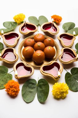 Mutlu Dussehra / Vijayadashami / Ayudh Puja tebrik kartı kullanarak apta/Bauhinia racemosa/çift yönlü yaprak ve Hint tatlı Rasgulla veya Kemalpaşa tatlısı için Navaratri Diya/kandil ile birlikte