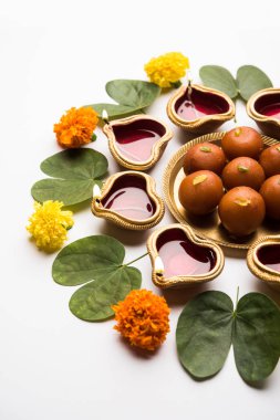 Mutlu Dussehra / Vijayadashami / Ayudh Puja tebrik kartı kullanarak apta/Bauhinia racemosa/çift yönlü yaprak ve Hint tatlı Rasgulla veya Kemalpaşa tatlısı için Navaratri Diya/kandil ile birlikte