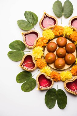 Mutlu Dussehra / Vijayadashami / Ayudh Puja tebrik kartı kullanarak apta/Bauhinia racemosa/çift yönlü yaprak ve Hint tatlı Rasgulla veya Kemalpaşa tatlısı için Navaratri Diya/kandil ile birlikte