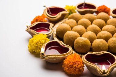 Diwali Rangoli Diya, çiçek ve Besan Laddu veya Laddoo arrabged beyaz arka plan üzerinde seçici odak kullanarak