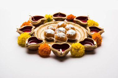 Diwali Rangoli Diya kullanarak, çiçek ve Motichoor Laddu veya Boondi Laddoo beyaz arka plan üzerinde seçici odak düzenlenmiş