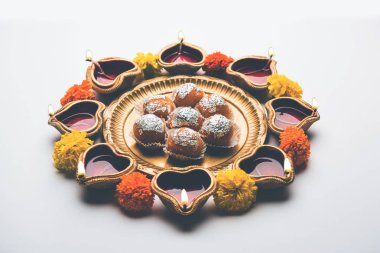 Diwali Rangoli Diya kullanarak, çiçek ve Motichoor Laddu veya Boondi Laddoo beyaz arka plan üzerinde seçici odak düzenlenmiş