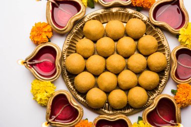 Diwali Rangoli Diya, çiçek ve Besan Laddu veya Laddoo arrabged beyaz arka plan üzerinde seçici odak kullanarak