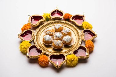 Diwali Rangoli Diya kullanarak, çiçek ve Motichoor Laddu veya Boondi Laddoo beyaz arka plan üzerinde seçici odak düzenlenmiş
