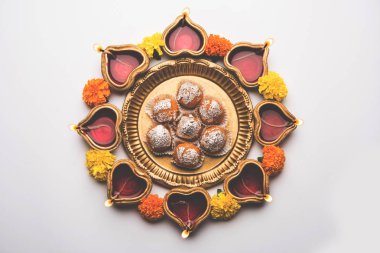 Diwali Rangoli Diya kullanarak, çiçek ve Motichoor Laddu veya Boondi Laddoo beyaz arka plan üzerinde seçici odak düzenlenmiş