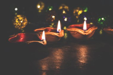 Diwali diya veya hediyeler, moody arka plan üzerinde çiçekler ile gece aydınlatma. Seçici odak