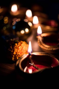 Diwali diya veya hediyeler, moody arka plan üzerinde çiçekler ile gece aydınlatma. Seçici odak