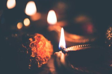 Diwali diya veya hediyeler, moody arka plan üzerinde çiçekler ile gece aydınlatma. Seçici odak