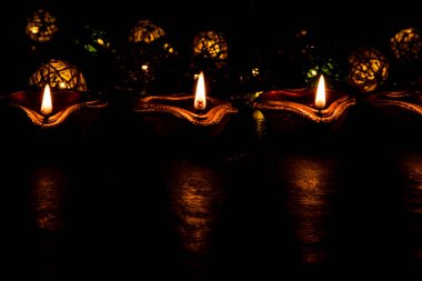 Diwali diya veya hediyeler, moody arka plan üzerinde çiçekler ile gece aydınlatma. Seçici odak