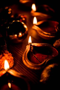 Diwali diya veya hediyeler, moody arka plan üzerinde çiçekler ile gece aydınlatma. Seçici odak