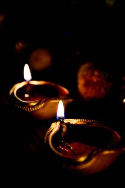 Diwali diya veya hediyeler, moody arka plan üzerinde çiçekler ile gece aydınlatma. Seçici odak