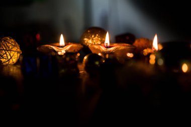 Diwali diya veya hediyeler, moody arka plan üzerinde çiçekler ile gece aydınlatma. Seçici odak