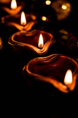 Diwali diya veya hediyeler, moody arka plan üzerinde çiçekler ile gece aydınlatma. Seçici odak