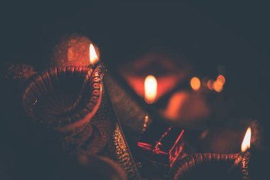 Diwali diya veya hediyeler, moody arka plan üzerinde çiçekler ile gece aydınlatma. Seçici odak