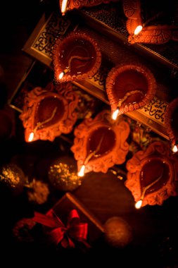 Diwali diya veya hediyeler, moody arka plan üzerinde çiçekler ile gece aydınlatma. Seçici odak