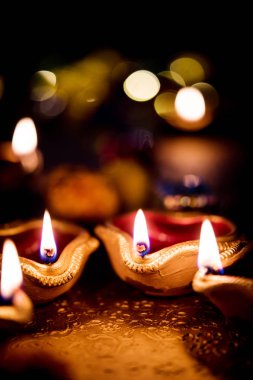 Diwali diya veya hediyeler, moody arka plan üzerinde çiçekler ile gece aydınlatma. Seçici odak