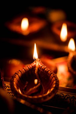 Diwali diya veya hediyeler, moody arka plan üzerinde çiçekler ile gece aydınlatma. Seçici odak