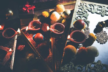 Diwali diya veya hediyeler, moody arka plan üzerinde çiçekler ile gece aydınlatma. Seçici odak